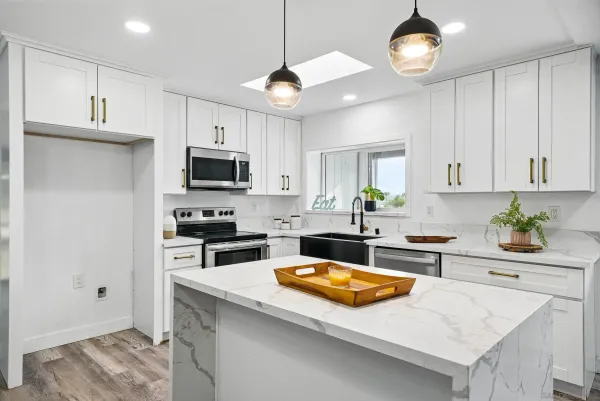 a kitchen with a stove a sink a microwave a refrigerator and cabinets