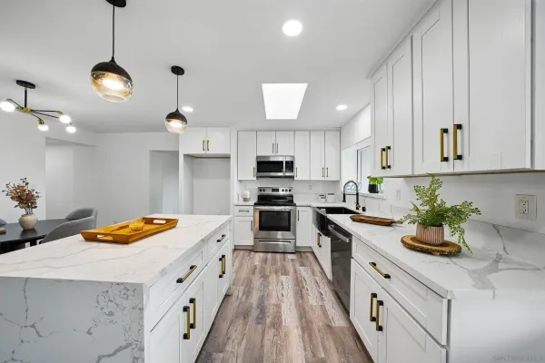 a kitchen with stainless steel appliances granite countertop a sink a stove top oven a counter space and cabinets