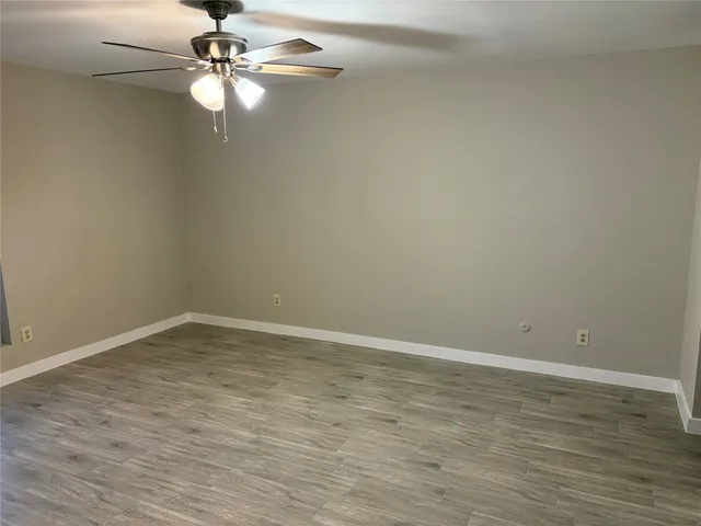 a view of a room with wooden floor and fan