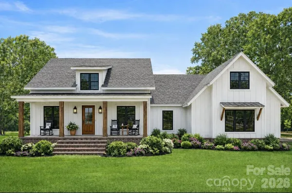 a view of house in front of a yard with potted plants