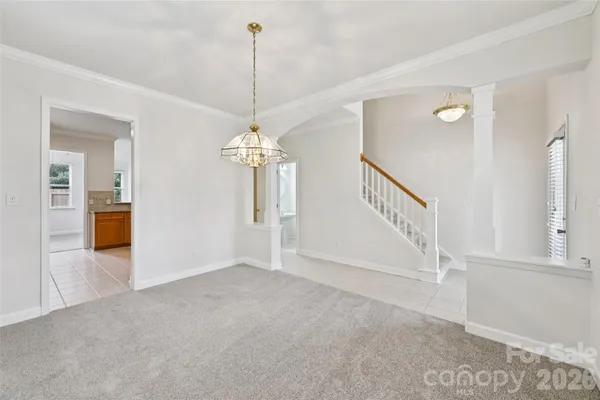 a view of an empty room and a chandelier fan