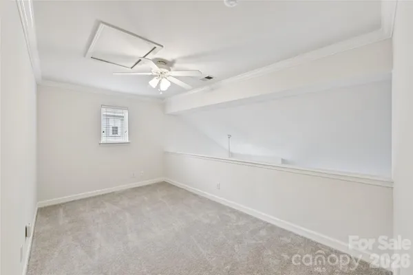 an empty room with a window and ceiling fan