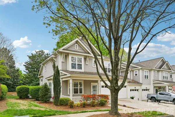 a front view of a house with garden and trees