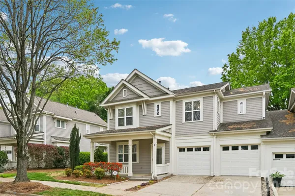 a front view of a residential houses with yard and trees