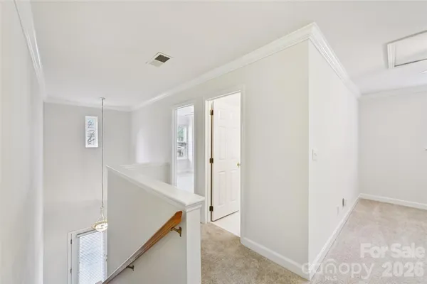 an empty room with chandelier fan and windows