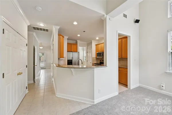a view of kitchen with stainless steel appliances refrigerator oven and white cabinets