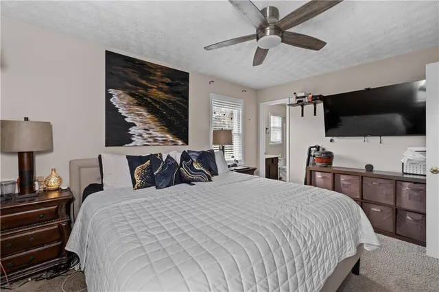 a bedroom with a bed a flat screen tv and a chandelier