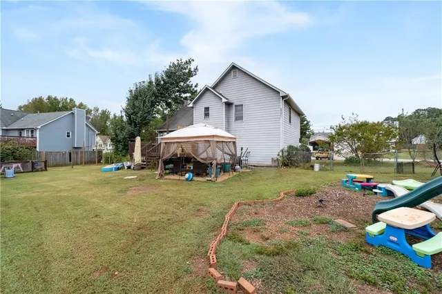 a view of a house with backyard and sitting area