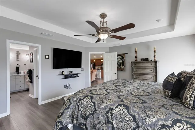 a bedroom with a bed and a flat tv screen on dresser