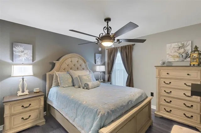 a bedroom with a bed a chandelier and a dresser