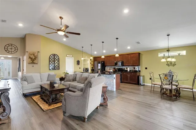 a living room with furniture kitchen view and a chandelier