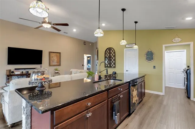 a kitchen with a counter space a sink appliances and a wooden floor