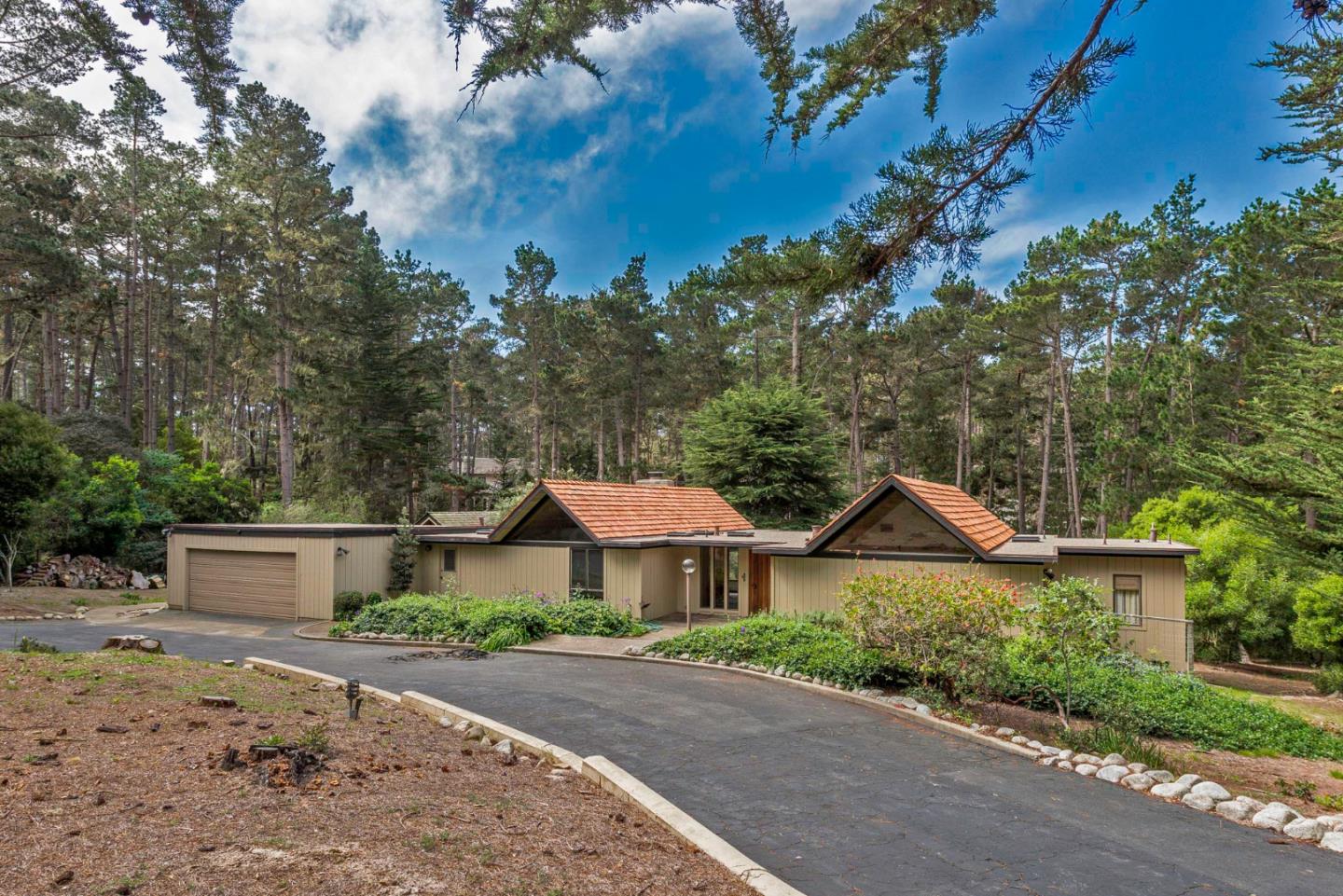 1280 Viscaino Road Pebble Beach, CA 93953 - Photo 3 of 48 a front view of a house with a yard and garage