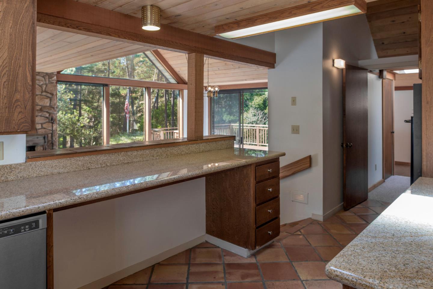 1280 Viscaino Road Pebble Beach, CA 93953 - Photo 36 of 48 a kitchen with granite countertop a sink and a large mirror