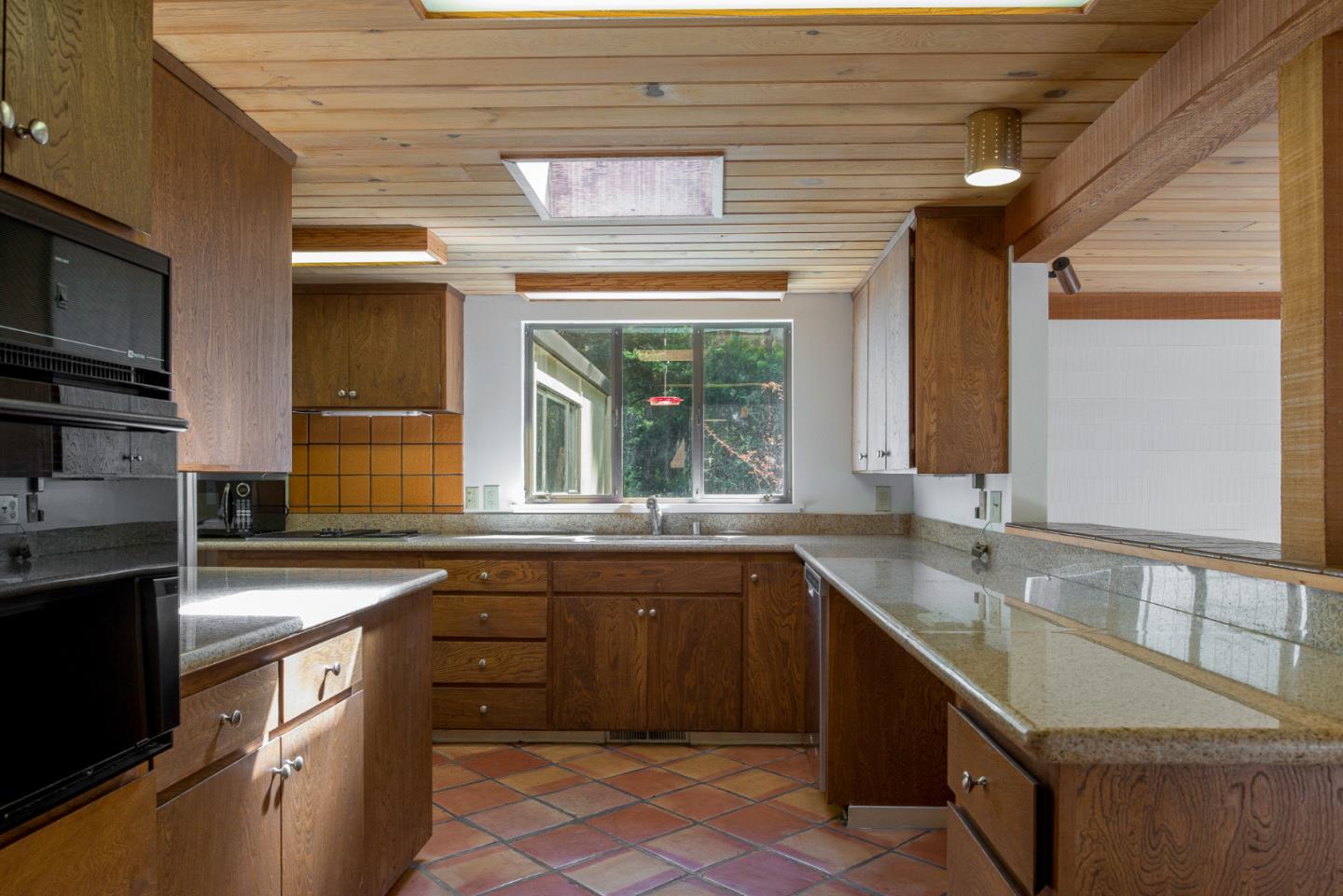 1280 Viscaino Road Pebble Beach, CA 93953 - Photo 10 of 48 a kitchen with a sink stove and cabinets