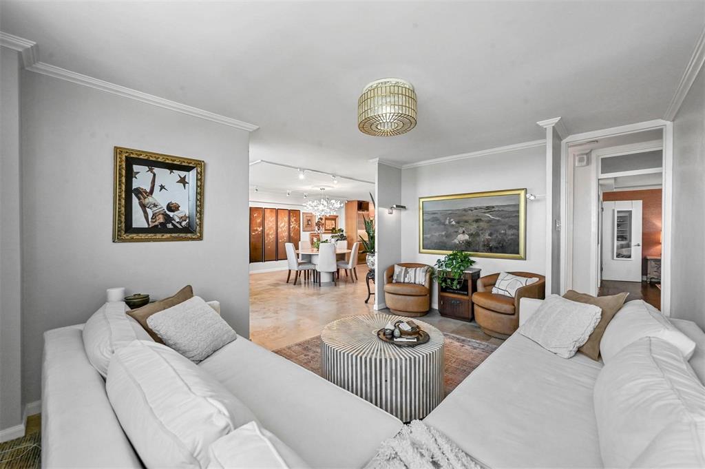 3883 Turtle Creek Boulevard, Unit 2015 Dallas, TX 75219 - Photo 13 of 31 Living area featuring ornamental molding and rail lighting