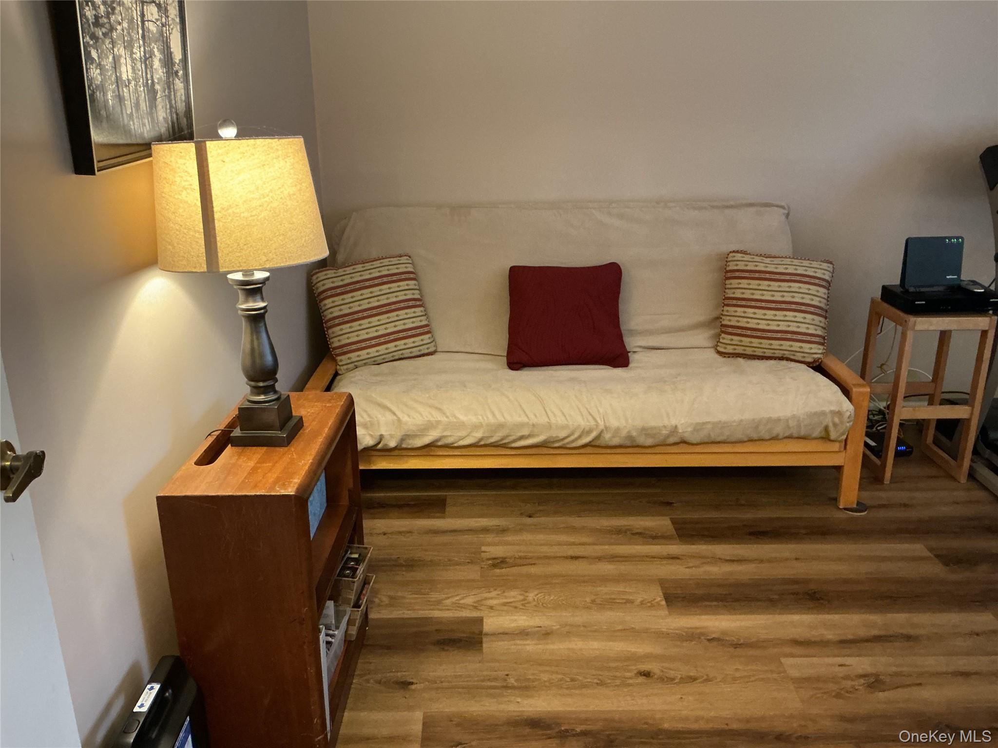 207 Woodbridge Drive, Unit B Ridge, NY 11961 - Photo 16 of 22 a bedroom with a bed and wooden floor