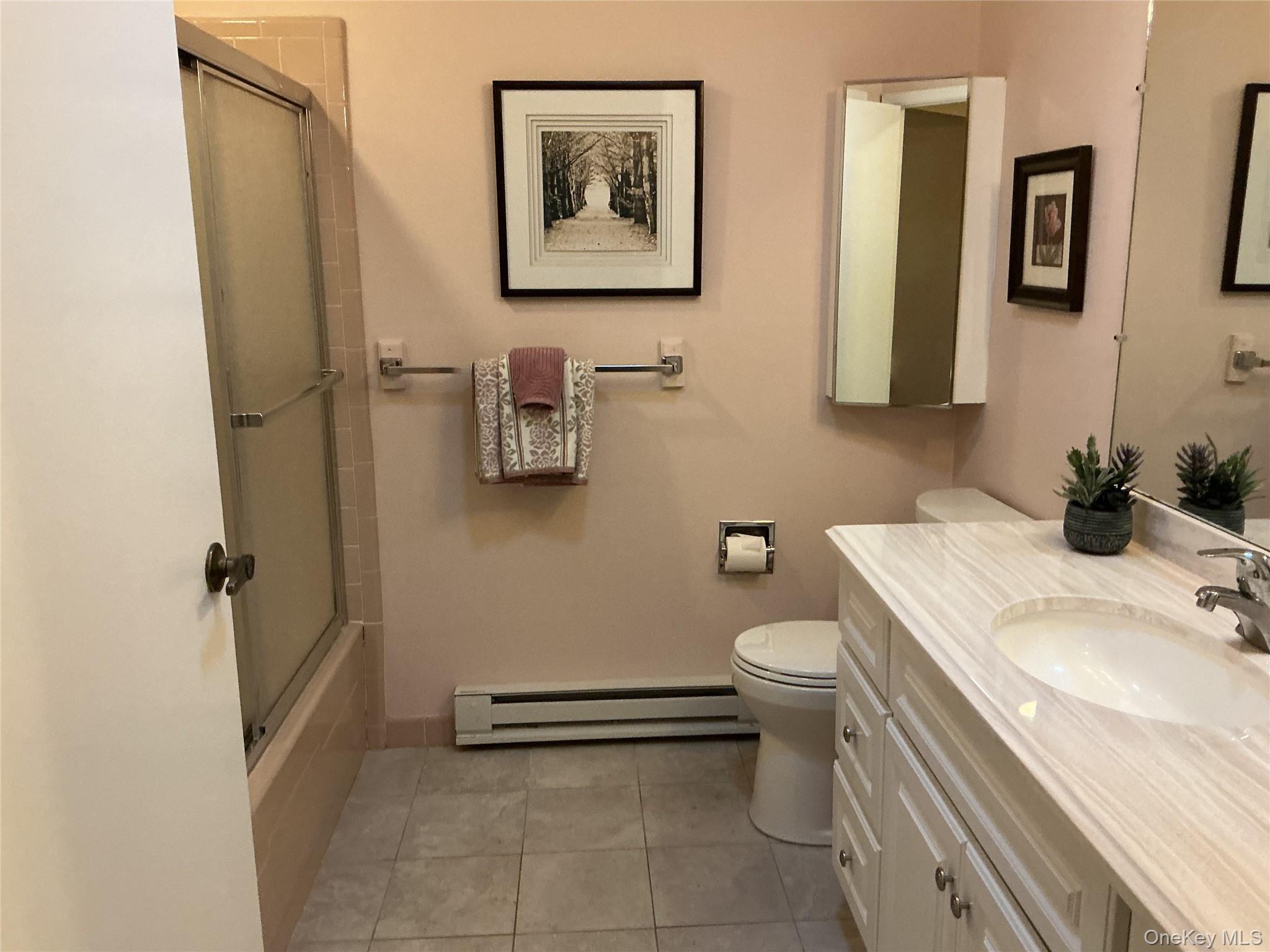 207 Woodbridge Drive, Unit B Ridge, NY 11961 - Photo 17 of 22 a bathroom with a sink a toilet and shower