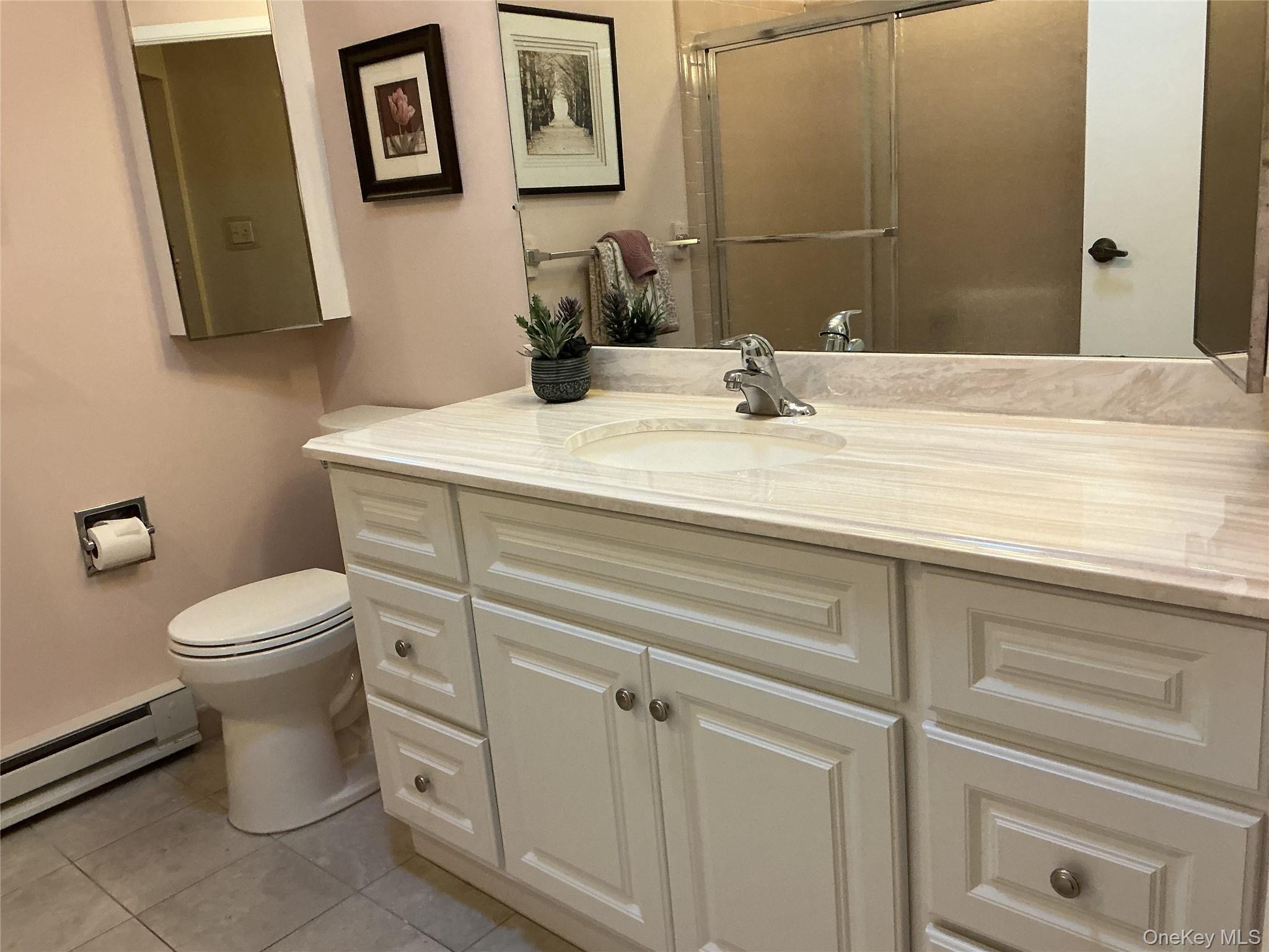 207 Woodbridge Drive, Unit B Ridge, NY 11961 - Photo 18 of 22 a bathroom with a toilet sink and mirror