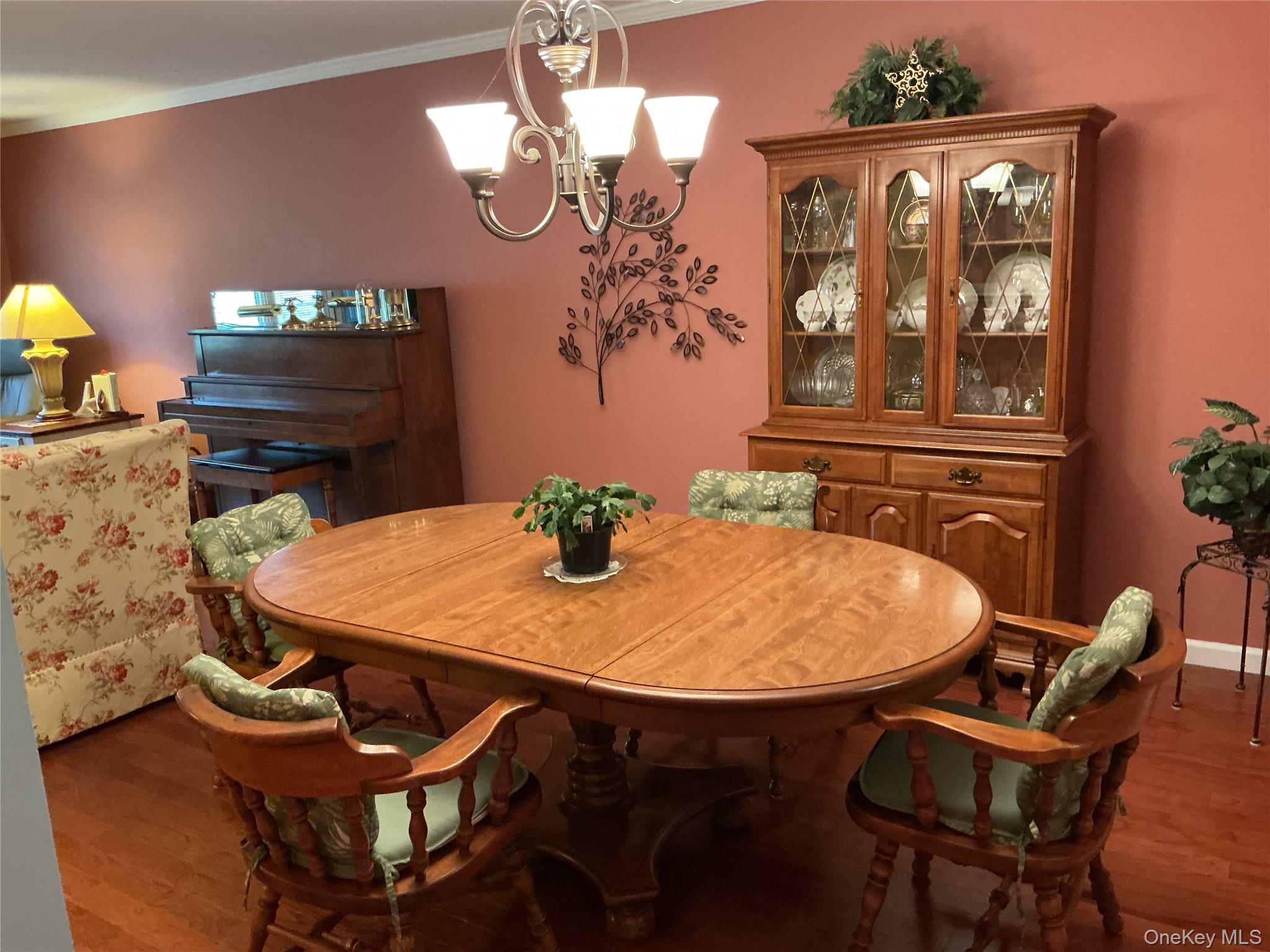 207 Woodbridge Drive, Unit B Ridge, NY 11961 - Photo 20 of 22 a view of a dining room with furniture and chandelier