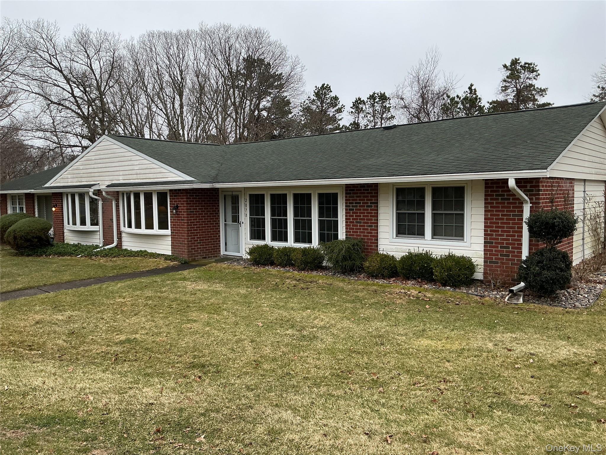 207 Woodbridge Drive, Unit B Ridge, NY 11961 - Photo 2 of 22 a view of a house with a backyard
