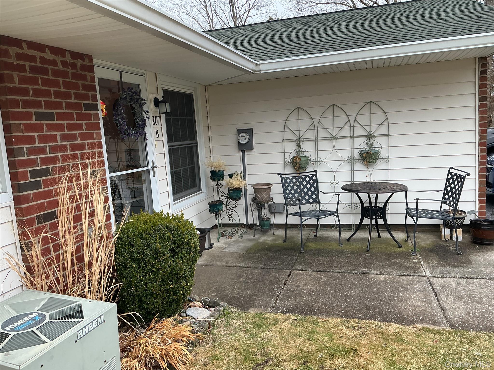 207 Woodbridge Drive, Unit B Ridge, NY 11961 - Photo 22 of 22 a view of a chairs and table in a patio