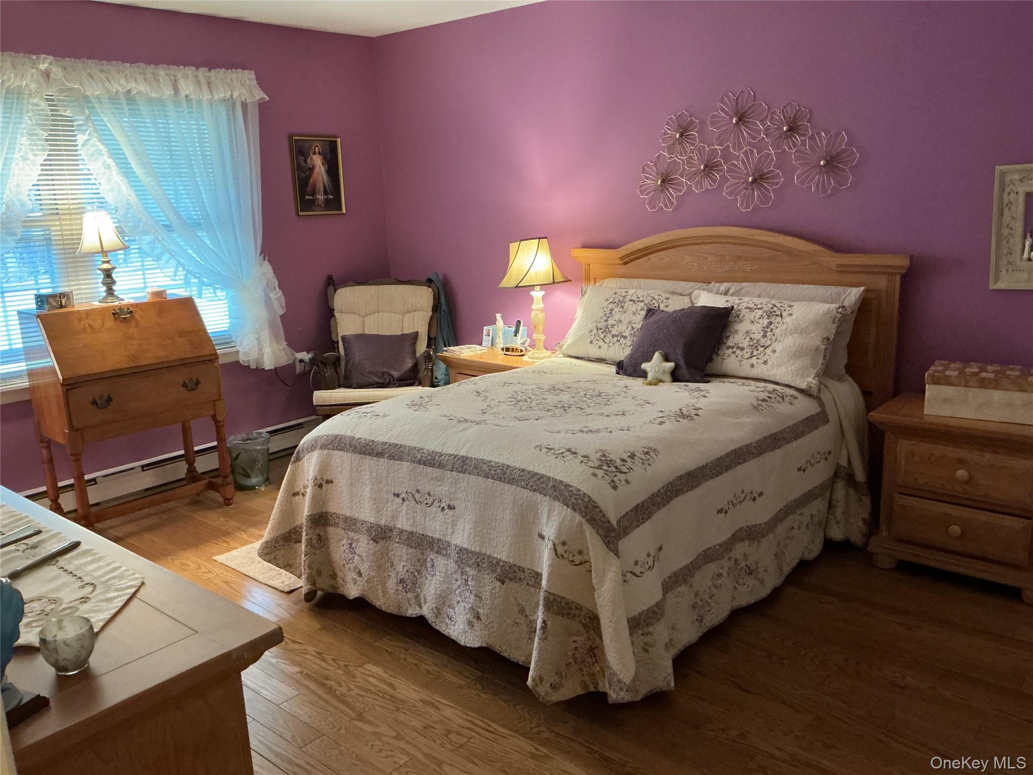 207 Woodbridge Drive, Unit B Ridge, NY 11961 - Photo 3 of 22 a bedroom with a bed and wooden floor
