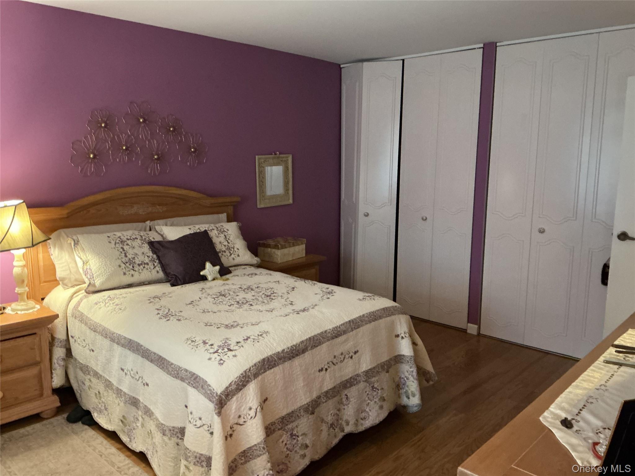 207 Woodbridge Drive, Unit B Ridge, NY 11961 - Photo 4 of 22 a bedroom with a bed and wooden floor