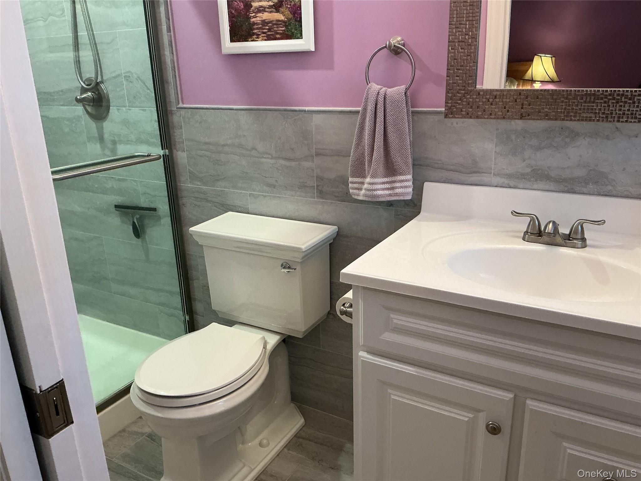 207 Woodbridge Drive, Unit B Ridge, NY 11961 - Photo 10 of 22 a bathroom with a sink a toilet and vanity