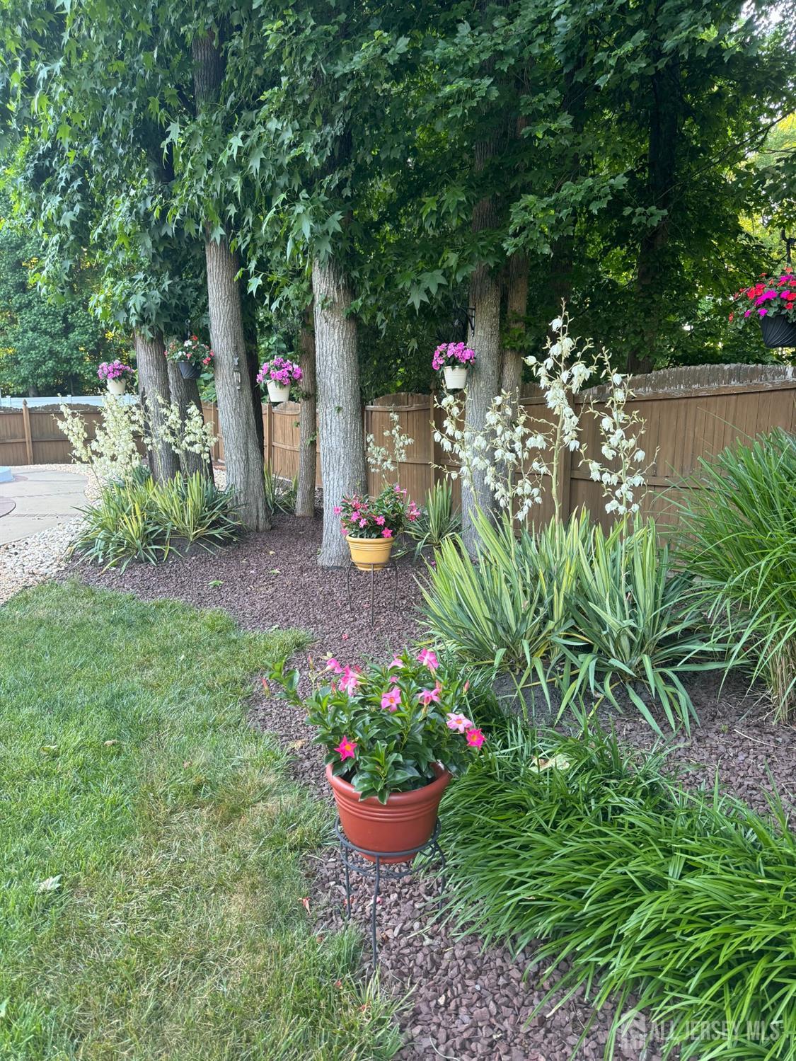14 Daniel Place Old Bridge, NJ 07747 - Photo 32 of 38 a view of a backyard with potted plants and large trees