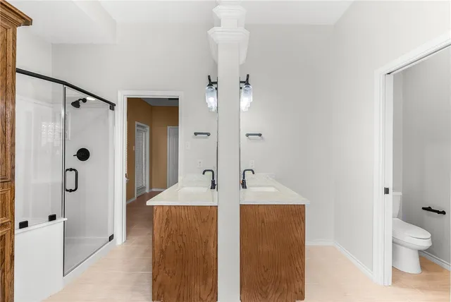 a en suite bathroom with a granite countertop sink a toilet and shower