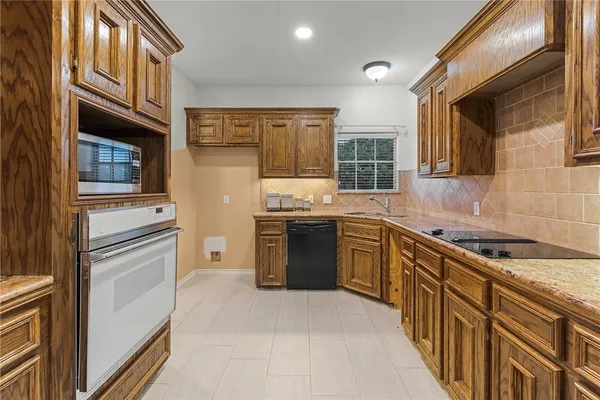 a kitchen with stainless steel appliances granite countertop a stove sink and cabinets