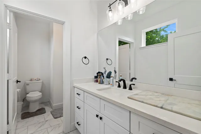 a bathroom with a sink a toilet and a mirror