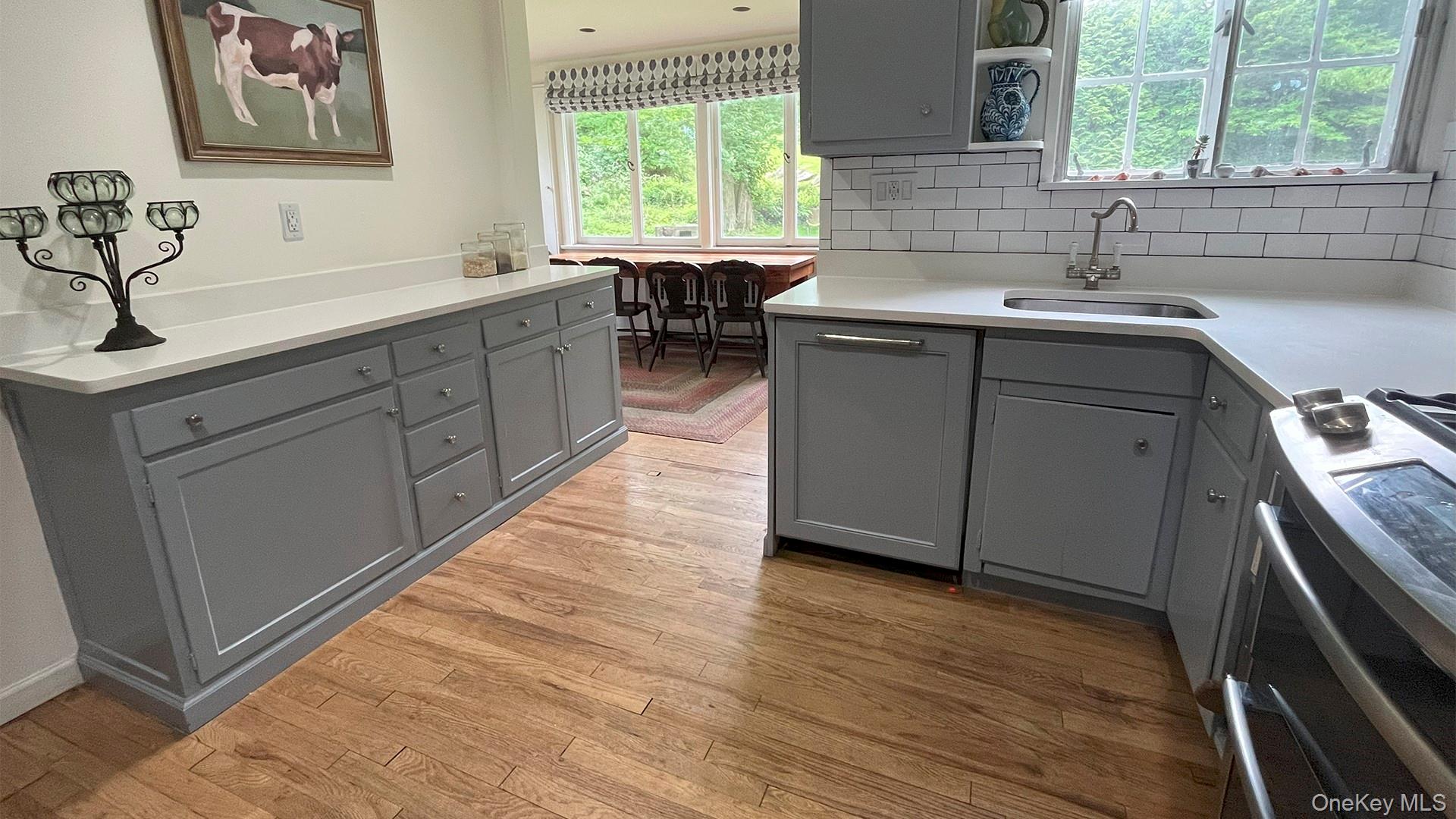 8 Holly Lane Rye, NY 10580 - Photo 5 of 27 Kitchen with gray cabinetry, stove, and light wood finished floors