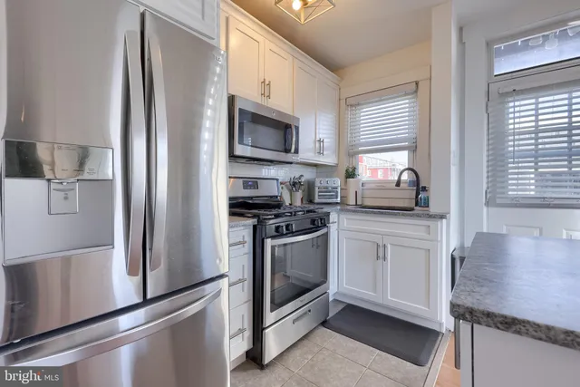 a kitchen with stainless steel appliances a refrigerator sink and microwave
