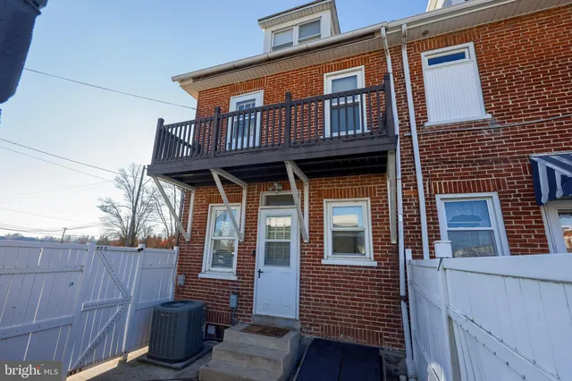 a view of a house with a window and wooden fence
