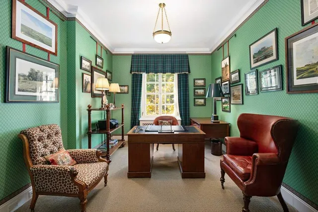 a living room with furniture a fireplace and large windows