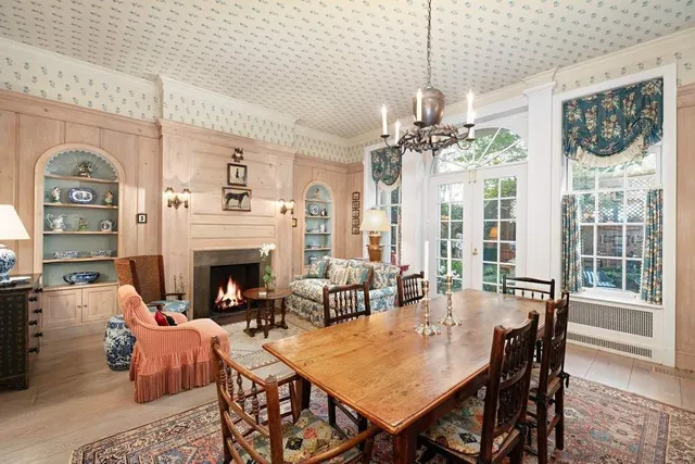 a living room with a black white checkered floor with a gaming machine and wooden floor