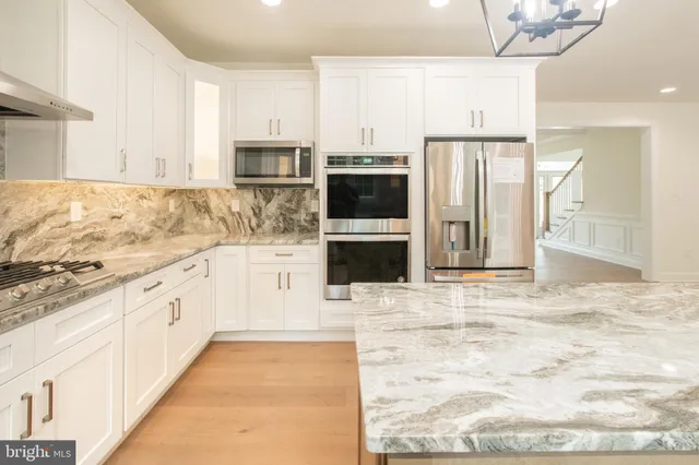 a large kitchen with kitchen island granite countertop a large counter space and stainless steel appliances