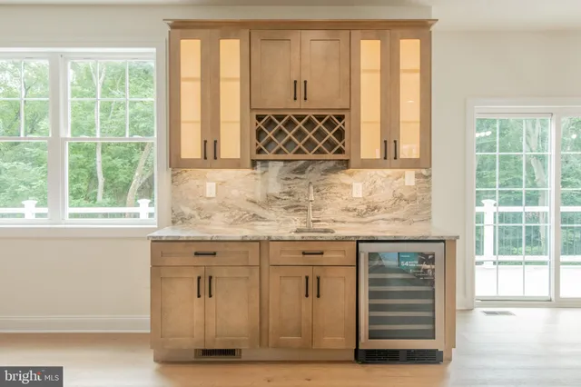 a large white kitchen with stainless steel appliances lots of white cabinets