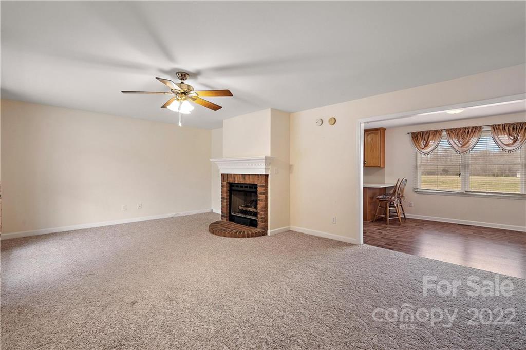 585 Windy Hill Road York, SC 29745 - Photo 12 of 38 an empty room with fireplace and fan