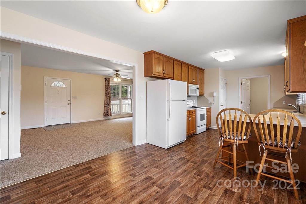 585 Windy Hill Road York, SC 29745 - Photo 15 of 38 a kitchen with furniture a refrigerator and wooden floor
