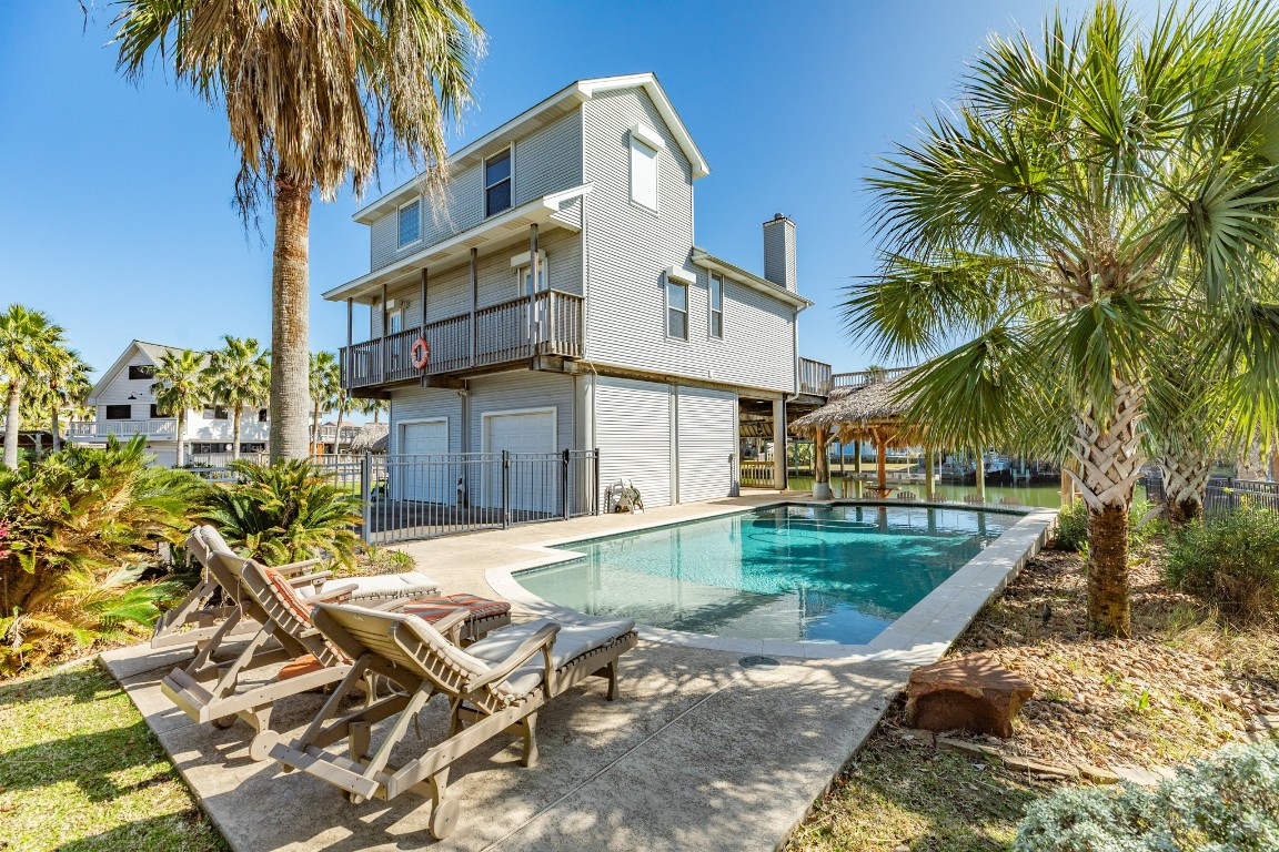 1319 Coral Way Tiki Island, TX 77554 - Photo 17 of 45 a view of a house with a swimming pool