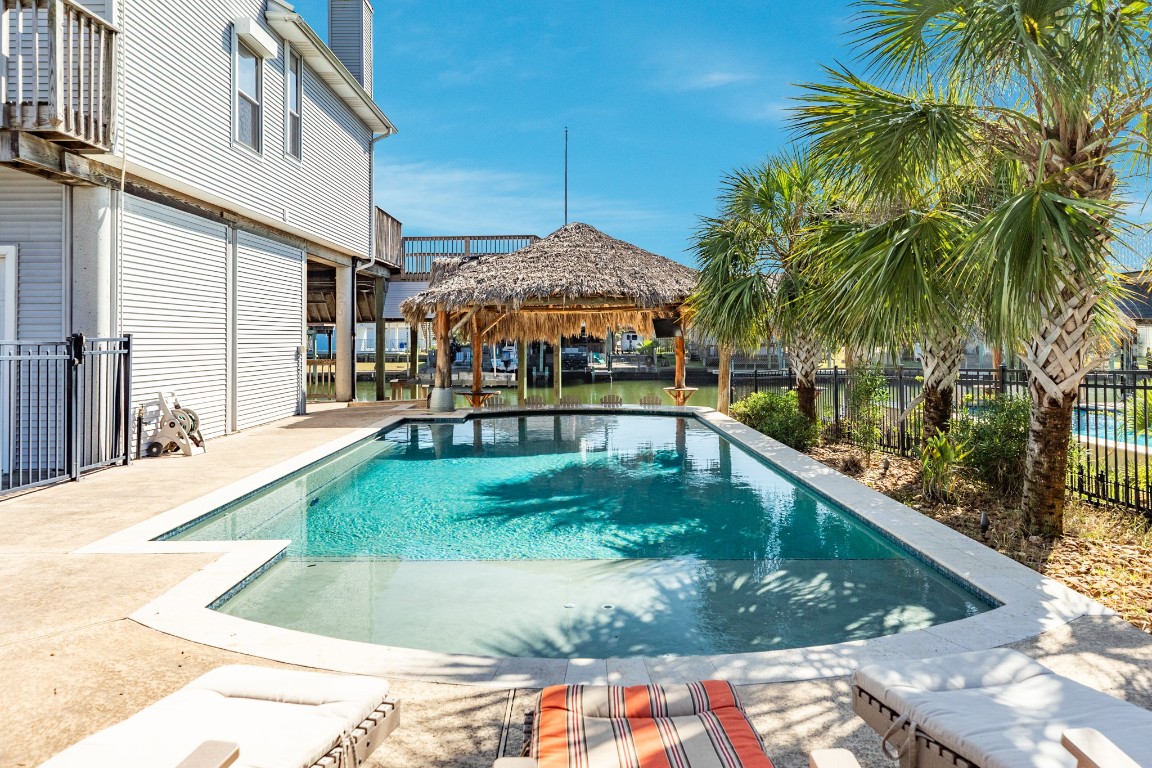 1319 Coral Way Tiki Island, TX 77554 - Photo 18 of 45 a view of a swimming pool with a patio