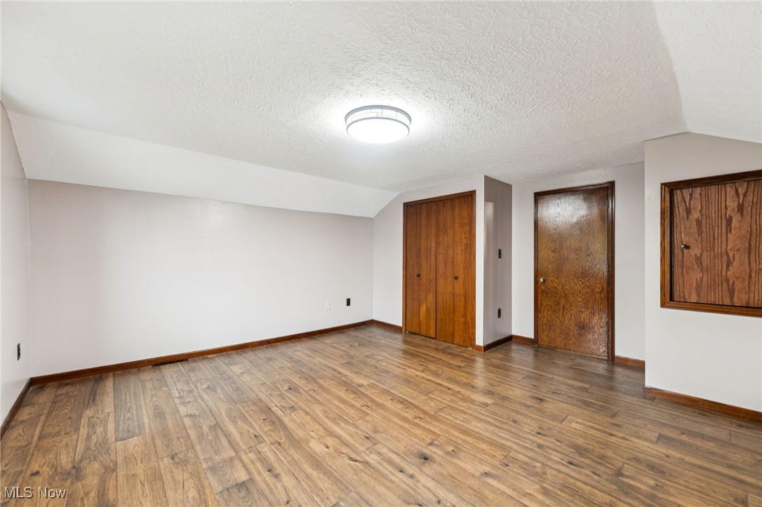12422 Portage Street Rittman, OH 44270 - Photo 23 of 42 Bonus room with lofted ceiling, hardwood / wood-style floors, and a textured ceiling