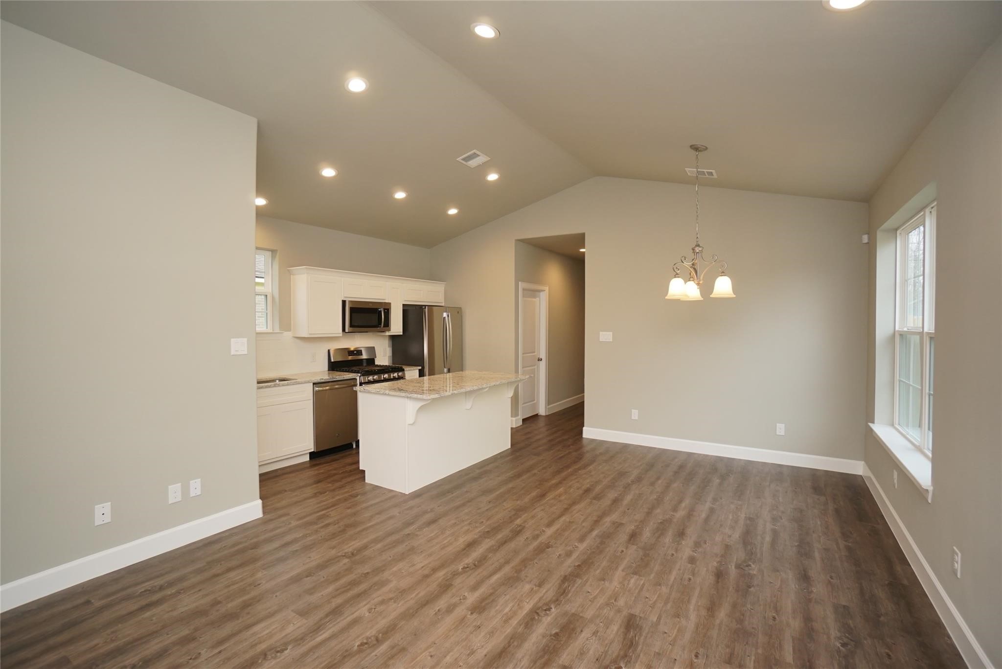 1137 4th Street Rosenberg, TX 77471 - Photo 5 of 16 a view of kitchen with microwave a refrigerator and wooden floor