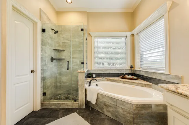 a spacious bathroom with a granite countertop tub a sink and a shower