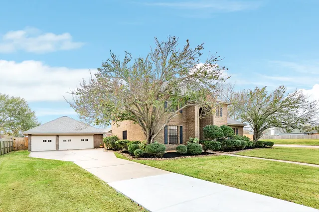 a front view of a house with a garden and trees
