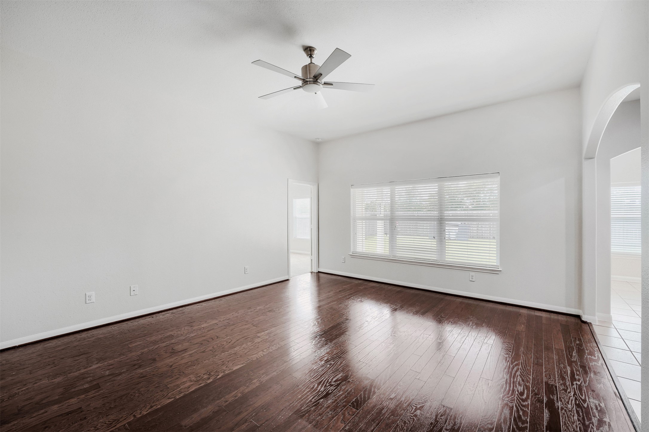 13408 Clara Martin Road Manor, TX 78653 - Photo 4 of 27 an empty room with wooden floor chandelier fan and windows