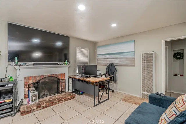 a view of a livingroom with a fireplace and a workspace
